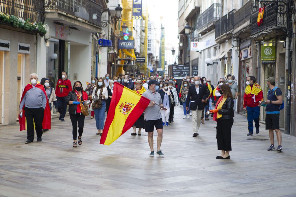 Manifestantes españoles con mascarilla protestan tocando una cacerola contra la gestión del gobierno español durante la pandemia del Covid-19 (Lago Loópez/Dreamstime)